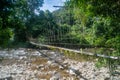 Suspension bridge across mountain river with rocks among tropical forest at the Mulu national park Royalty Free Stock Photo