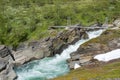 Suspension Bridge in the Mountains over fast flowing turbulent river