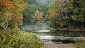 Suspension bridge over Black river in Michigan upper peninsula surrounded by fall foliage Royalty Free Stock Photo