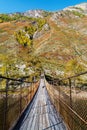 Suspension bridge over a mountain river in a gorge Royalty Free Stock Photo