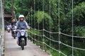 Suspension bridge over the river with motorcycle crossing on it in the morning in Sukabumi, west java, Indonesia. traditional