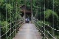 Suspension bridge over the river with motorcycle crossing on it in the morning in Sukabumi, west java, Indonesia. traditional