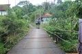 Suspension bridge over the river with motorcycle crossing on it in the morning in Sukabumi, west java, Indonesia. traditional