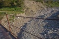 A narrow old rusty river crossing . Dirty, stony river . a suspension bridge still made of an iron stand was used to cross the Royalty Free Stock Photo