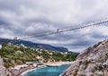 Suspension bridge to the Diva rock, Black Sea coast, near Yalta, Crimea. Panorama of the town of Simeiz Royalty Free Stock Photo