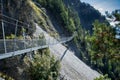Suspension bridge crossing a scree slope in the Swiss Alps, Valais, Switzerland. Royalty Free Stock Photo