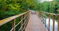 Suspension bridge and walking wooden path over the lake on an autumn evening