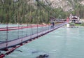 A suspension bridge over a wide river in the mountains.