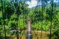 Suspension wooden narrow bridge at jungle river with rocks in forest at the Mulu national park Royalty Free Stock Photo