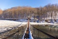 Suspention bridge over the mountain river winter view. Royalty Free Stock Photo