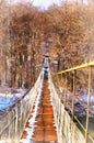 Suspention bridge over the mountain river winter view Royalty Free Stock Photo