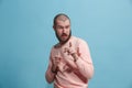 Suspiciont. Doubtful pensive man with thoughtful expression making choice against blue background Royalty Free Stock Photo