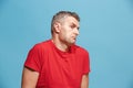 Suspiciont. Doubtful pensive man with thoughtful expression making choice against blue background Royalty Free Stock Photo