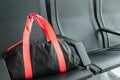 Suspicious black sport bag left on chairs unattended. Lost luggage. Concept of safety in public places and terrorism Royalty Free Stock Photo