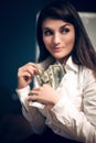 Business woman sitting on table with pile of dollar bills. Royalty Free Stock Photo