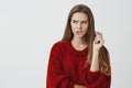 Suspicious girlfriend trying to think up way to pick password of smartphone. Portrait of focused anxious good-looking