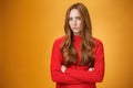 Suspicious intense and defensive ginger girl standing in passive-aggressive pose pouting and frowning looking with Royalty Free Stock Photo