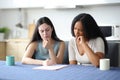 Suspicious interracial roommates reading a contrat in the kitchen Royalty Free Stock Photo