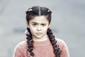 Suspicious look. Kanekalon strand in braids of child. Braided hairstyle concept. Girl with braided hair style pink