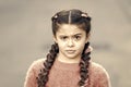 Suspicious look. Kanekalon strand in braids of child. Braided hairstyle concept. Girl with braided hair style pink