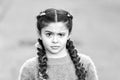 Suspicious look. Kanekalon strand in braids of child. Braided hairstyle concept. Girl with braided hair style pink