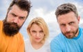 Suspicious look. They know what you did. Threesome suspiciously look down. Woman and men look confident sky background