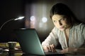 Suspicious woman checking laptop content in the night Royalty Free Stock Photo