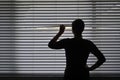 Suspicious woman looking outside through a venetian curtain blinds Royalty Free Stock Photo