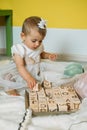 Sustainable eco-friendly safe wooden toys for baby and kids. Baby girl play with wooden blocks made with organic Royalty Free Stock Photo