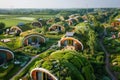 A sustainable eco-village featuring unique cottages with green roofs and solar panels, nestled in a serene agricultural landscape