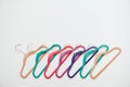 Sustainable responsible consumption concept. Many bright multi-colored velvet pop color hangers on white background. Store, sale,