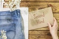 Jeans on textile bag and female hand holding inscription second hand