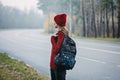 Sustainable tourism, responsible travel. Young woman traveler with backpack in pine forest background.