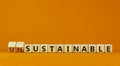 Sustainable or unsustainable symbol. Turned a cube and changed word `unsustainable` to `sustainable` on wooden cubes. Beautifu Royalty Free Stock Photo