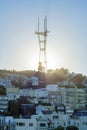 Sutro tower in late afternoon sun with beams in evening twilight and neighborhoods with houses and homes in the city