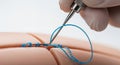 Suture Thread Being Applied on a Skin Model by a Surgeon Using Forceps in a Clinical Environment with White Background in Extreme Royalty Free Stock Photo