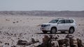 SUV car in centre of a quarry desert