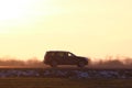 SUV car driving fast on intercity road at sunset. Highway traffic in evening