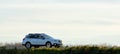 SUV car driving fast on intercity road at sunset. Highway traffic in evening