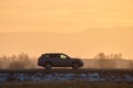 SUV car driving fast on intercity road at sunset. Highway traffic in evening