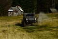 SUV crossing puddle and making splash. Extreme and four wheel drive concept. Off road car in black color takes part in Royalty Free Stock Photo