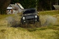 SUV crossing puddle and making splash. Off road car in black color takes part in racing. Extreme and four wheel drive Royalty Free Stock Photo