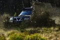 SUV or offroad car on path covered with grass crossing puddle with dirt splash. Extreme, challenge and 4x4 vehicle Royalty Free Stock Photo