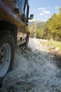 Suv offroad 4wd car rides through muddy puddle, off-road track road, with a big splash Royalty Free Stock Photo