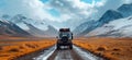 the suv is parked on a road with mountains in the background Royalty Free Stock Photo