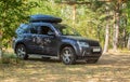 SUV in a pine forest on a meadow Royalty Free Stock Photo