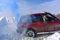 SUV `Range Rover` 4x4 quickly actively drives through the snow in blue smoke, and a man looking out of the window Royalty Free Stock Photo