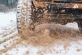 the SUV rides on snow and mud, off-road, close view of the car wheel, the concept of traffic safety in winter