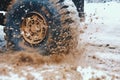 the SUV rides on snow and mud, off-road, close view of the car wheel, the concept of traffic safety in winter