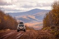 SUV on scenic autumn road in the forest Royalty Free Stock Photo